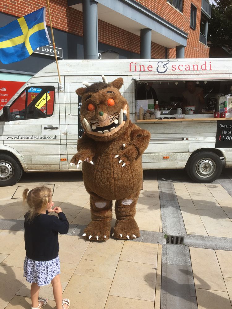 A little girl meeting the Gruffalo by a food van