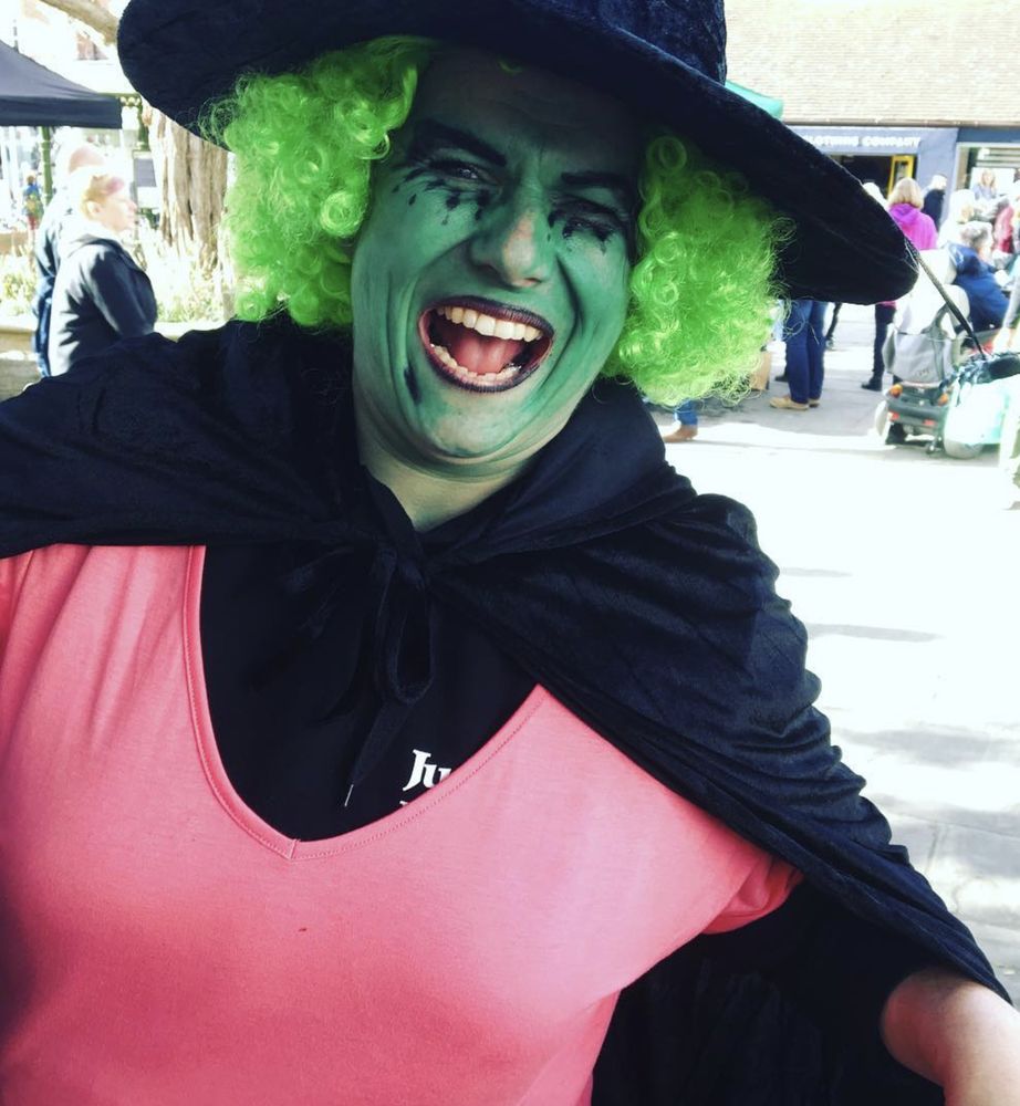 A laughing green-faced witch in a pointed hat